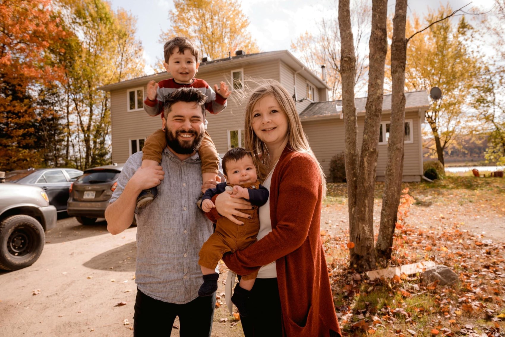 A young family in front of their home