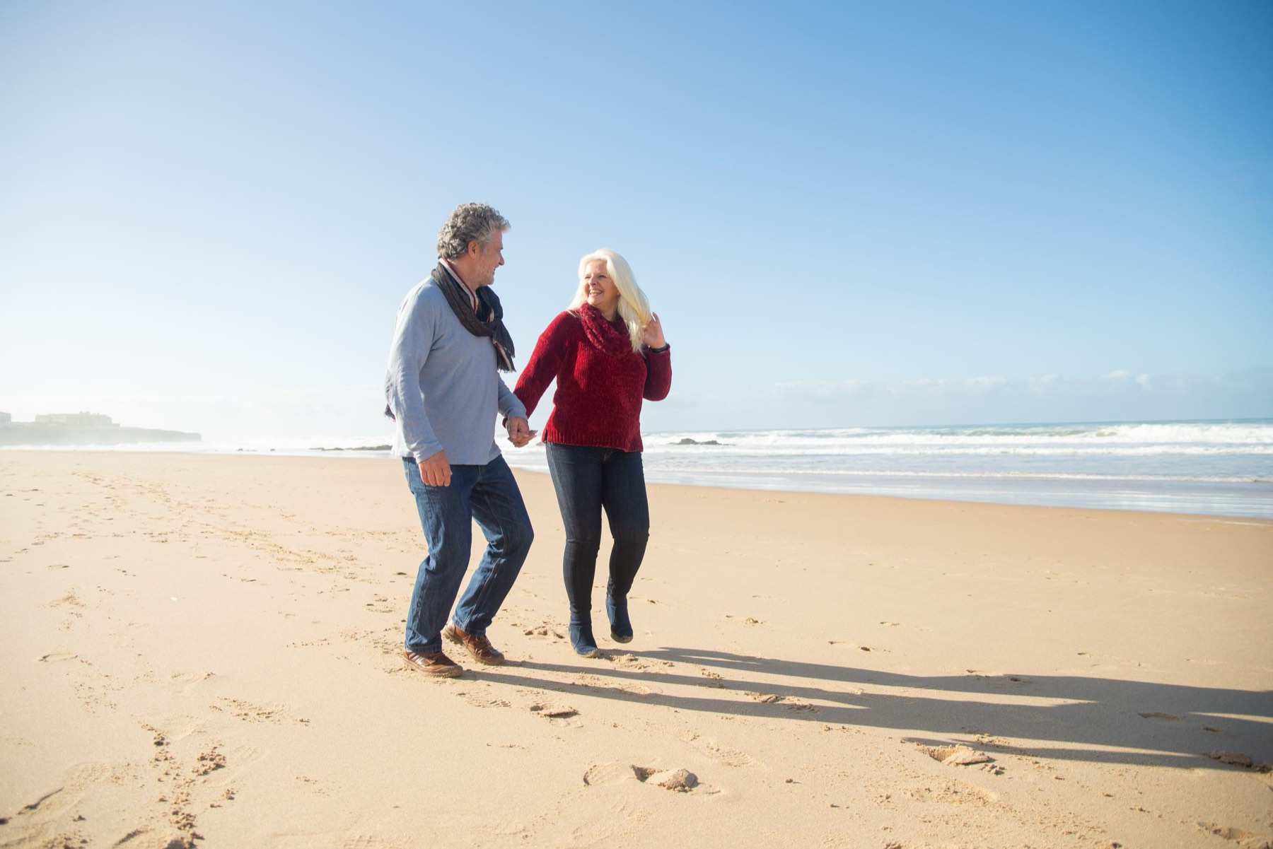 A couple walking a beach together in a secure, well-planned retirement